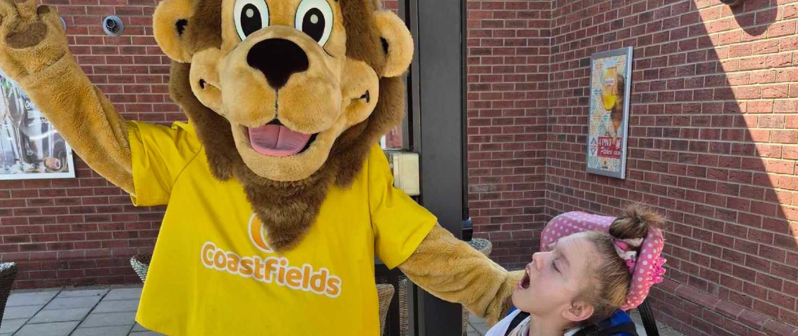 Rose Marie with a person dressed in a lion constume at a UK holiday park
